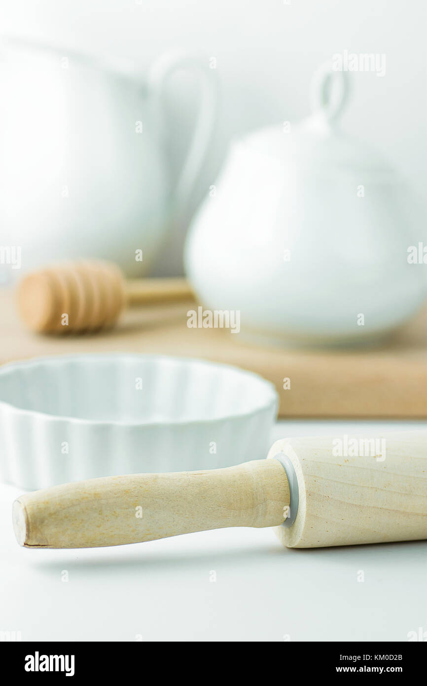 Backen essentials Utensilien auf weißen Tischplatte Schüssel Holz Nudelholz Honig Pendelarm kanne Krug Schneidebrett. Urlaub Weihnachten Ostern. Küche Innenraum Stockfoto