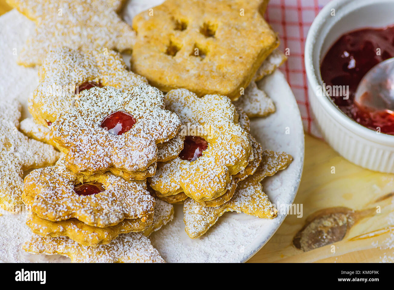 Home gebackene Lebkuchen und Shortbread Cookies in verschiedenen Formen sterne haus Blume mit Marmelade Linzer gepudert. Platte Holz Tisch Küche Handtuch gemütliche Festliche ein Stockfoto