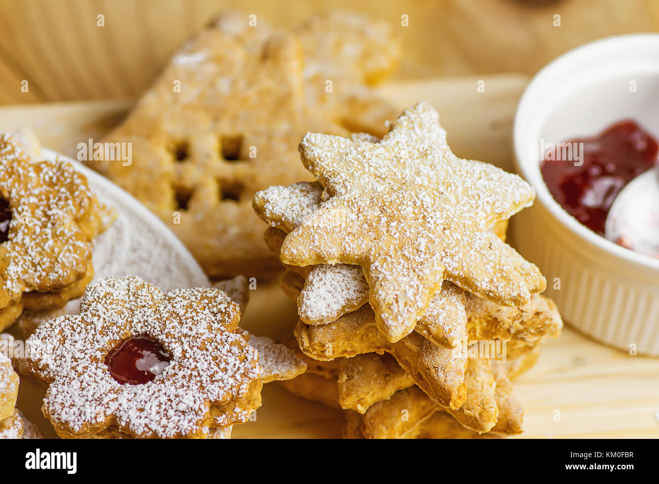 Stapel von hausgemachte Lebkuchen und Plätzchen linzer Cookies in verschiedenen Formen sterne haus Blume mit Marmelade gepudert. Holz Tisch. nach oben Anzeigen weiches Licht gemütliche f Stockfoto