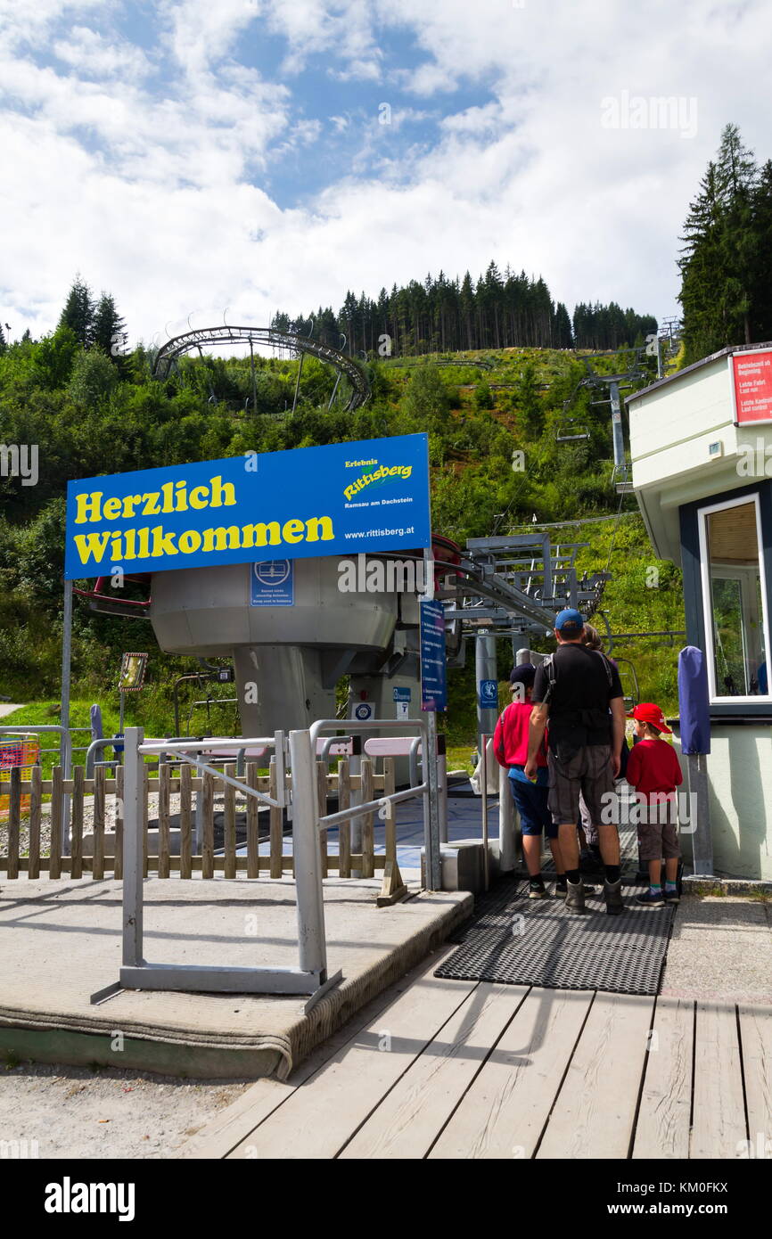 Ramsau am Dachstein, Österreich - 17. August: Leute, die sich vor der Achterbahn Bobbahn Rodelbahn in rittisberg Vergnügungspark Stockfoto