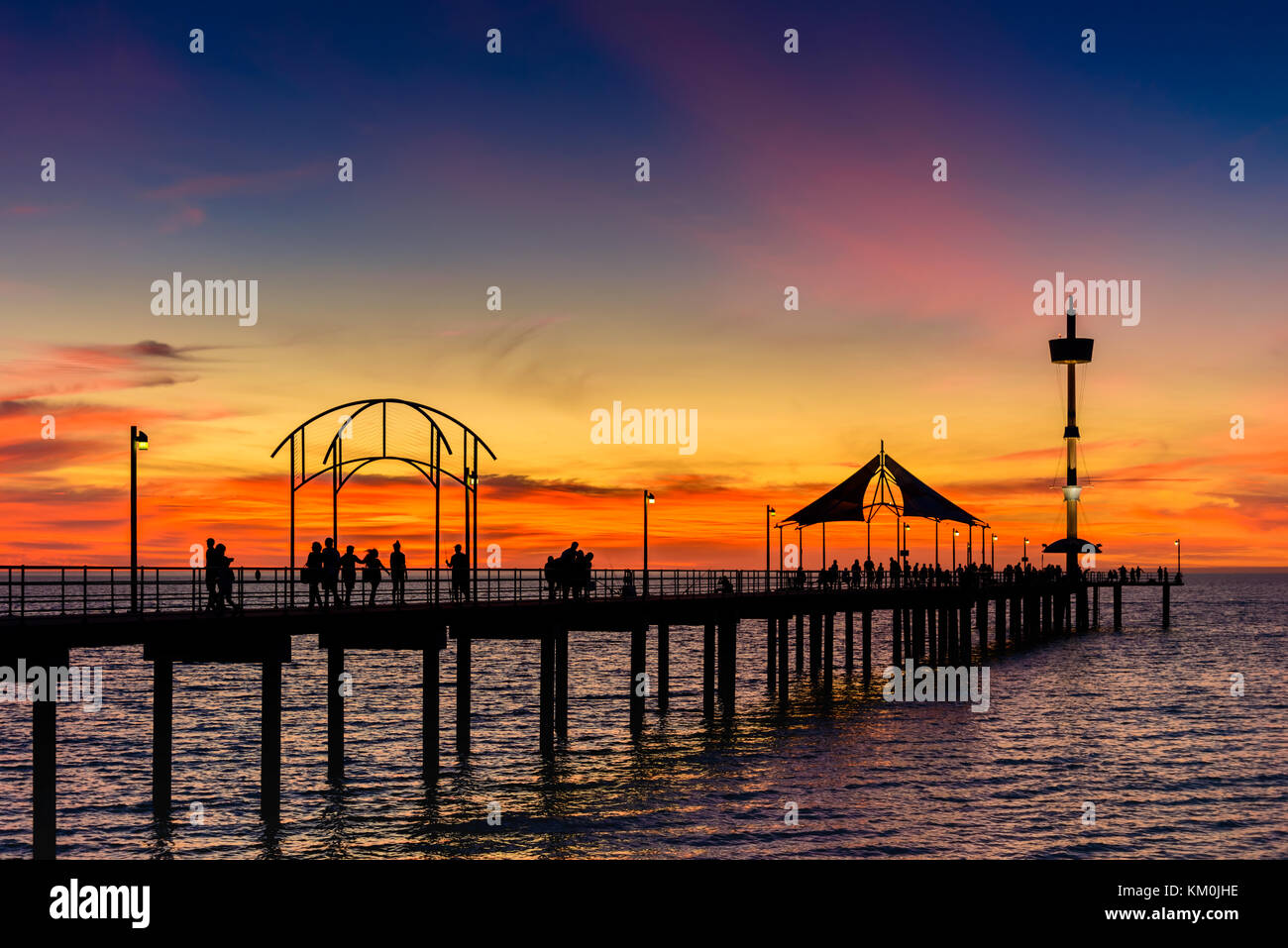 Menschen zu Fuß entlang der Brighton Pier bei Sonnenuntergang. South Australia Stockfoto