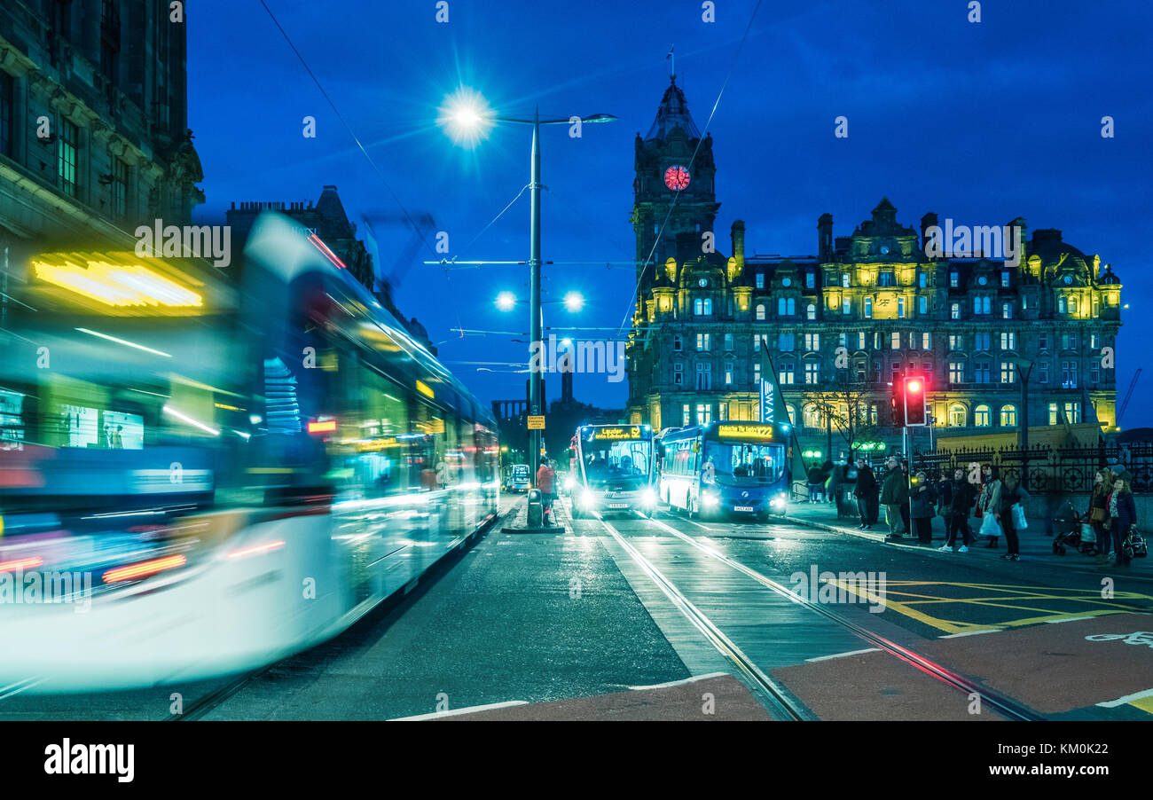 Nachtansicht der Princes Street mit Straßenbahn und Bussen und Balmoral Hotel im Hintergrund in Edinburgh, Schottland, Großbritannien. Stockfoto