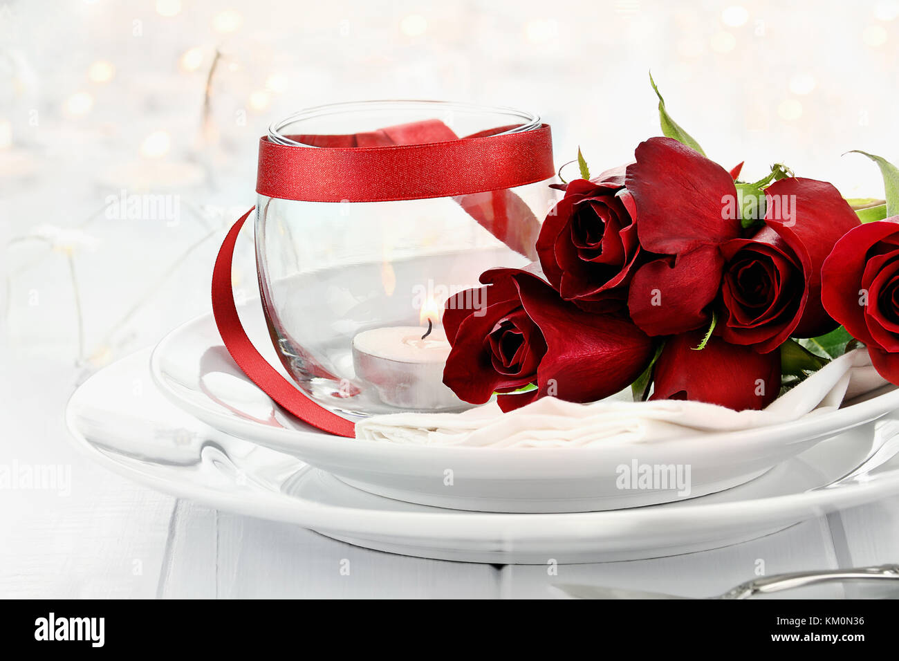 Romantischen candlelite Tabelle Einstellung mit langem Stiel Rote Rosen und Kerzen im Hintergrund. geringe Tiefenschärfe mit selektiven Fokus auf Rosen. Stockfoto