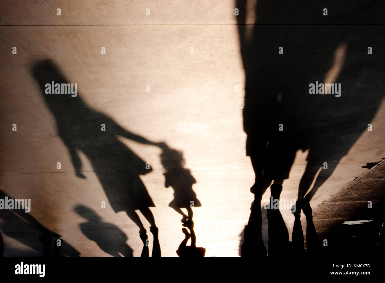 Verschwommene Schatten Silhouetten von Menschen und eine Mutter mit Kind zu Fuß auf misty Sommer promenade Stockfoto