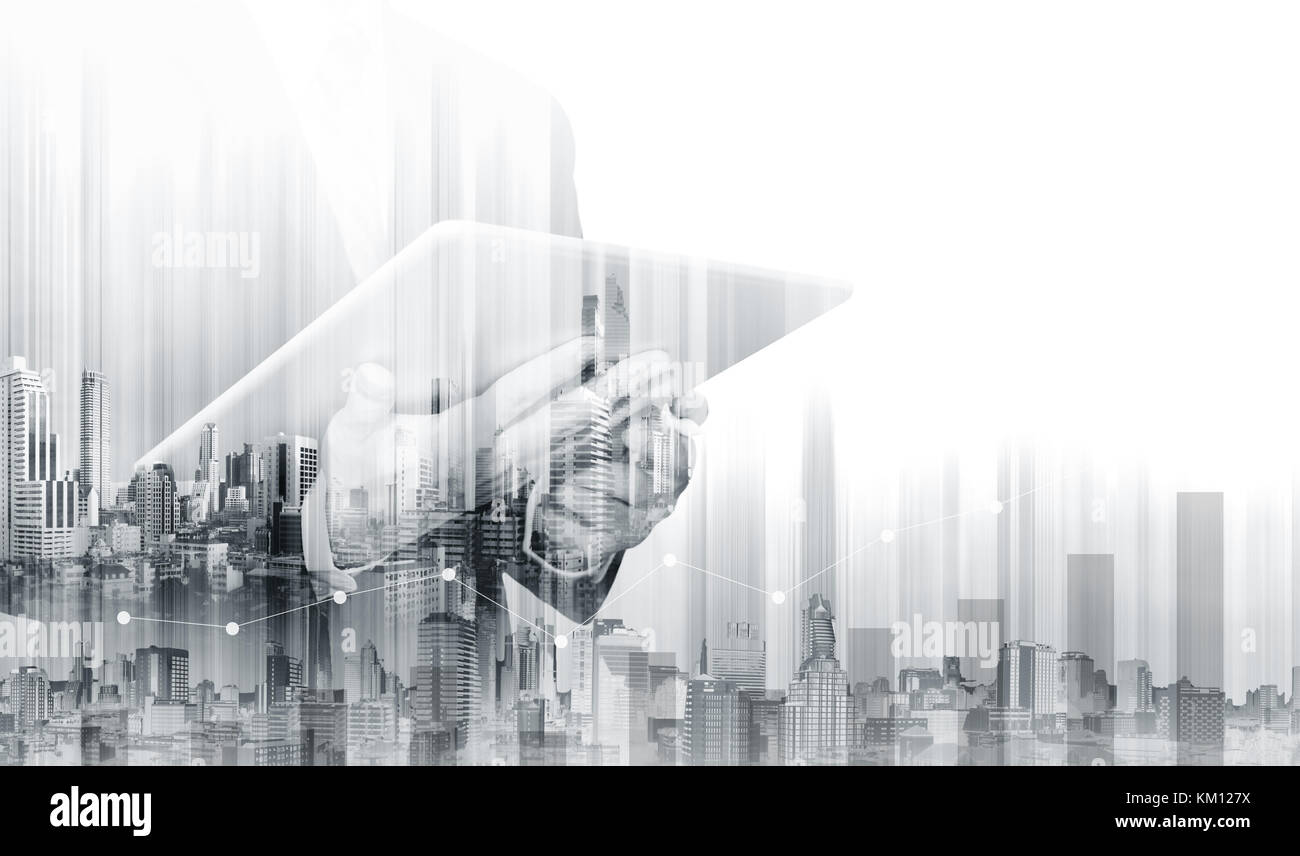 Geschäftsmann mit doppelter Belichtung, der an einem digitalen Tablet mit modernen Gebäuden arbeitet. Geschäftswachstum und Investitionen Stockfoto