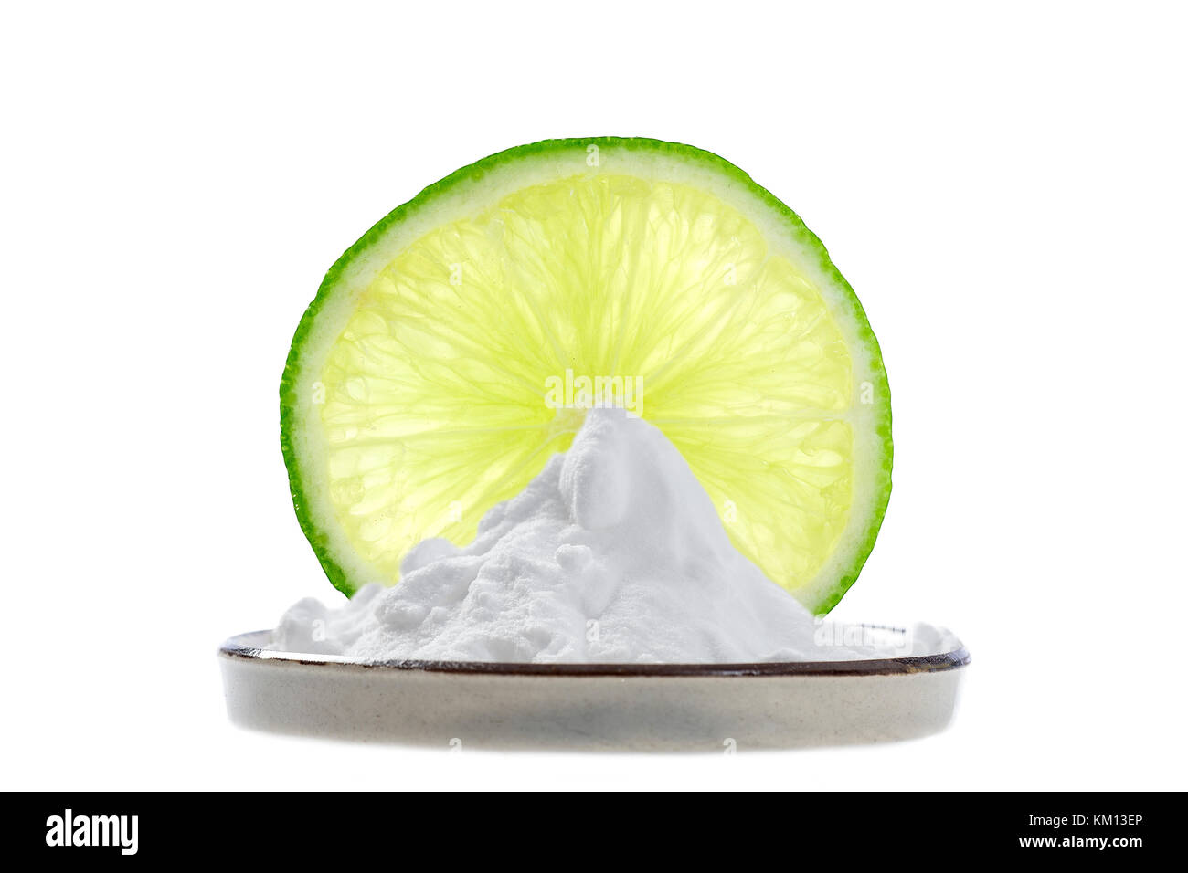 Natron in eine Schale mit einer feinen Schicht von Zitrone und zwei ganze Kalk hinter Stockfoto