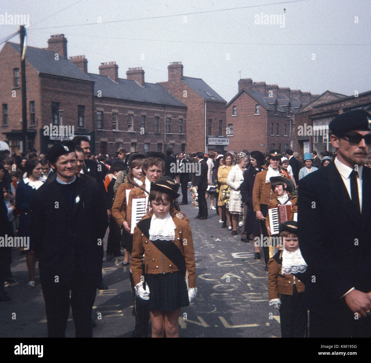 IRA Farbe Partei und republikanische Ostern Parade auf beechmount Avenue West Belfast 1970. Diese Ostern Parade signalisiert die Spaltung zwischen der offiziellen und der Provisional IRA. Der Official IRA verwendet Stick auf Ostern Lillies (so wurde als die Stickies bekannt) und die Provisional IRA trug Stift auf der Abzeichen. Dies ist die PIN auf Parade Stockfoto