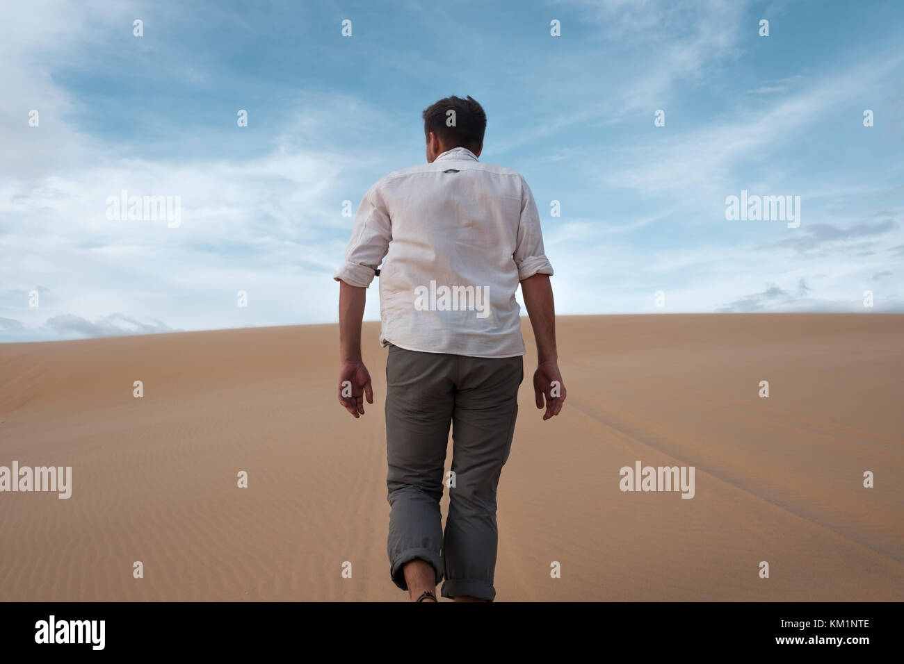 Kaukasischen jungen Mann, der gerade auf seine Weise auf sandige Wüste Stockfoto