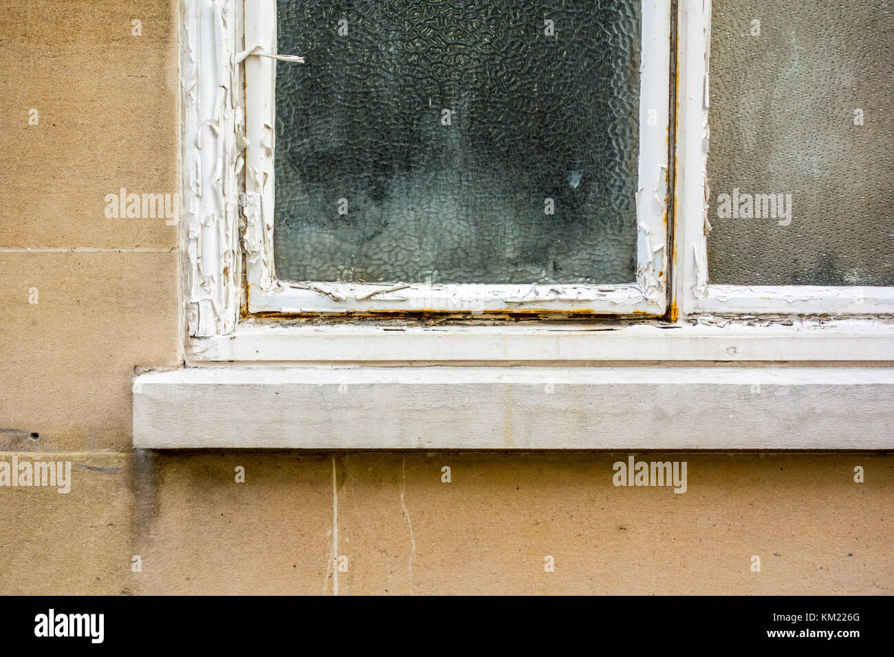 Abblätternde Farbe auf einem alten Fenster mit Milchglas privacy Glas Stockfoto