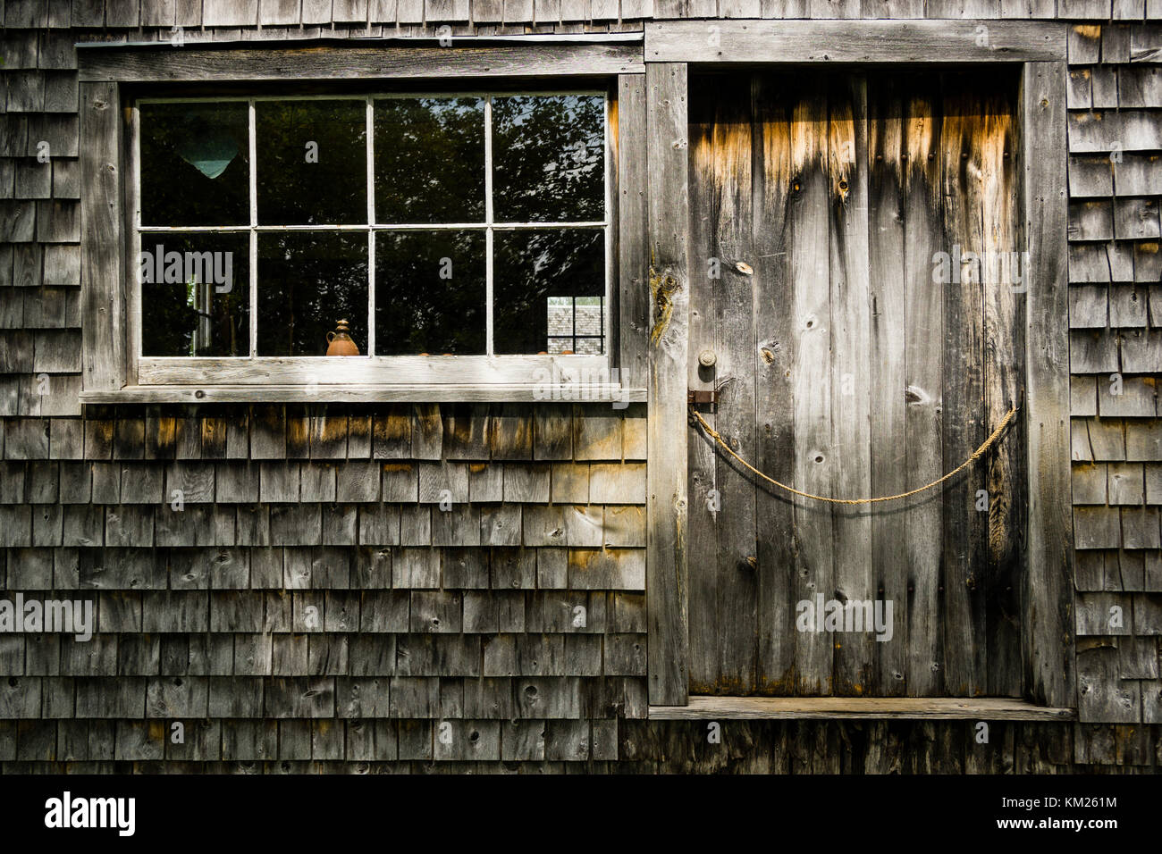 Tür und Fenster in eine verwitterte Holzhütte mit unfertigen Schindel Abstellgleis, in Sherbrooke Village, Nova Scotia, Kanada. Stockfoto