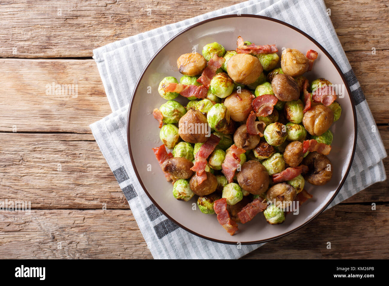 Gebratene Kastanien, Rosenkohl und Speck closeup auf einem Teller. horizontal oben Ansicht von oben Stockfoto