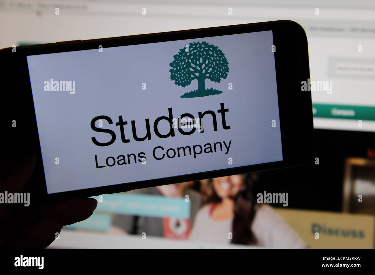 Der Student Loans Company Logo auf einem Telefon mit der Website, die auf einem Bildschirm Stockfoto