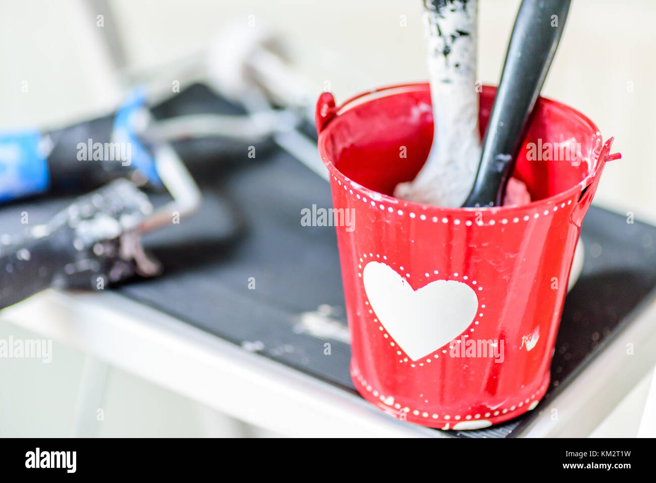 Tagesansicht roten Eimer mit Herz und zwei Pinsel innen. Valentinstag Dekoration Konzept. Stockfoto