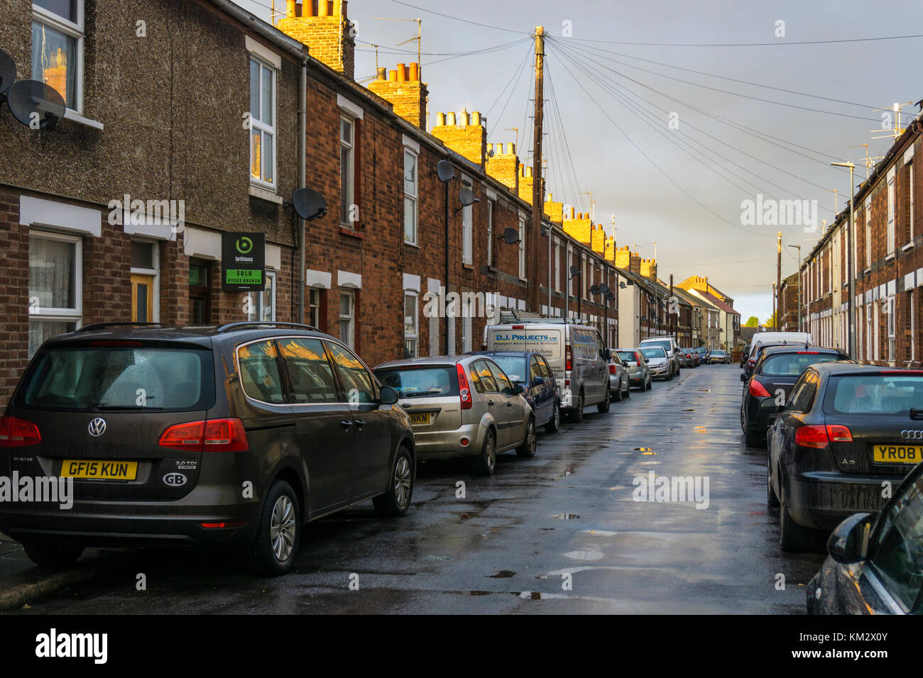 Parkplatz auf der Straße in einer Straße mit Reihenhäusern, King's Lynn. Stockfoto