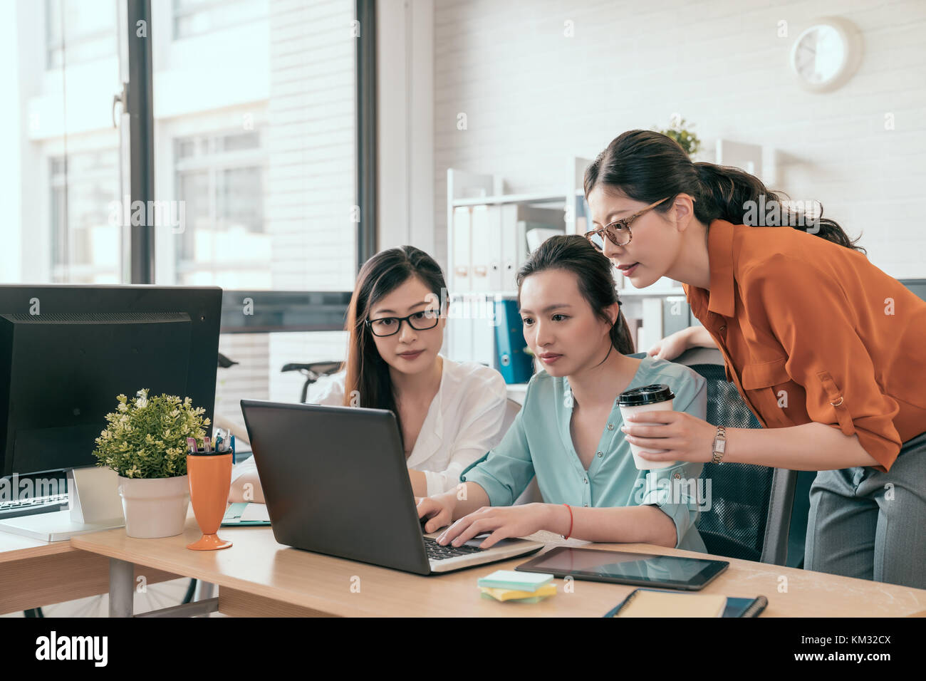 Werfen Sie einen Blick auf dieses Diagramm! Junge hübsche Frauen mit Laptop Computer, während Sie im Büro sitzen auf Business Meeting mit Kollegen Stockfoto