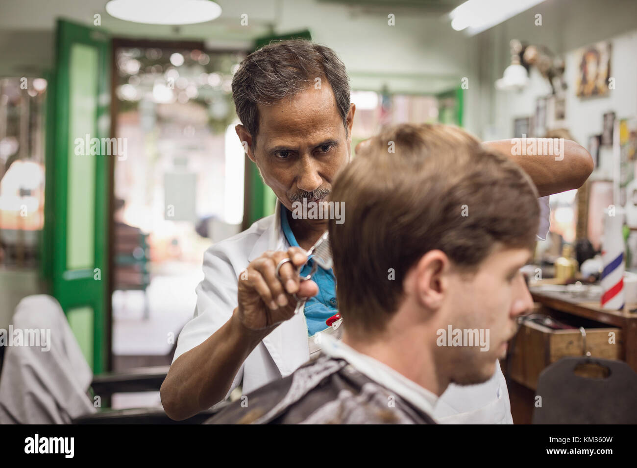 Malaiische Friseur bei der Arbeit Stockfoto