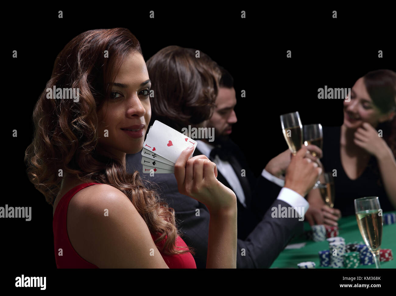 Frau am Roulette Tisch holding Champagner Glas in Casino Stockfoto