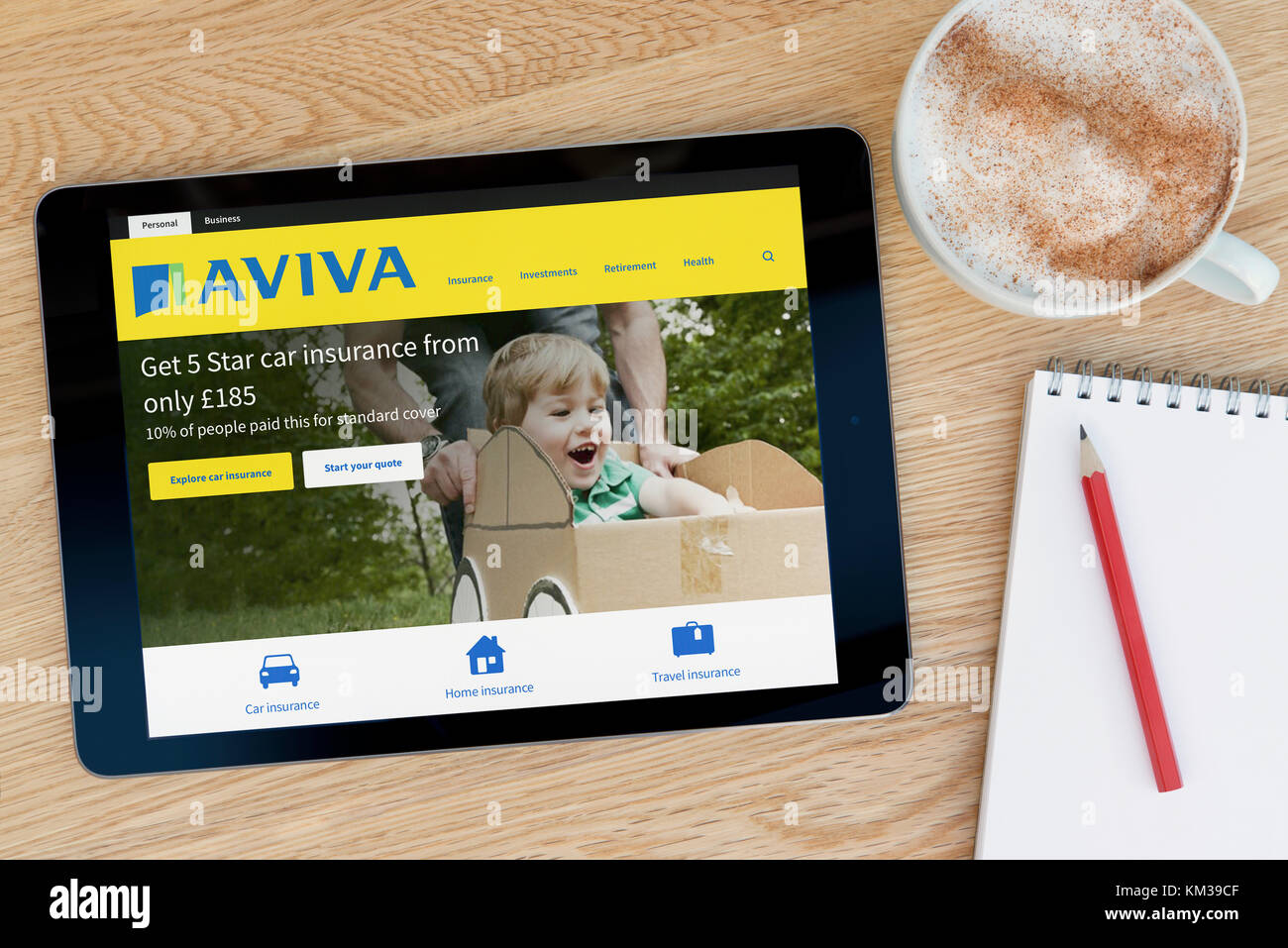 Das Aviva Website auf einem iPad Tablet Gerät, das auf einem Tisch liegt neben einem Notizblock und Bleistift und eine Tasse Kaffee (nur redaktionell) Stockfoto