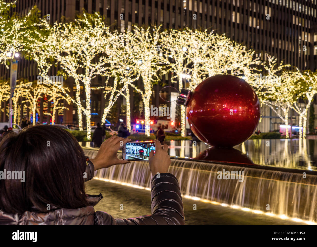 New York, NY USA - 26. November 2017. Weihnachtszeit in der New York City Avenue of Americas mit einem Mädchen, das Fotos macht. Stockfoto