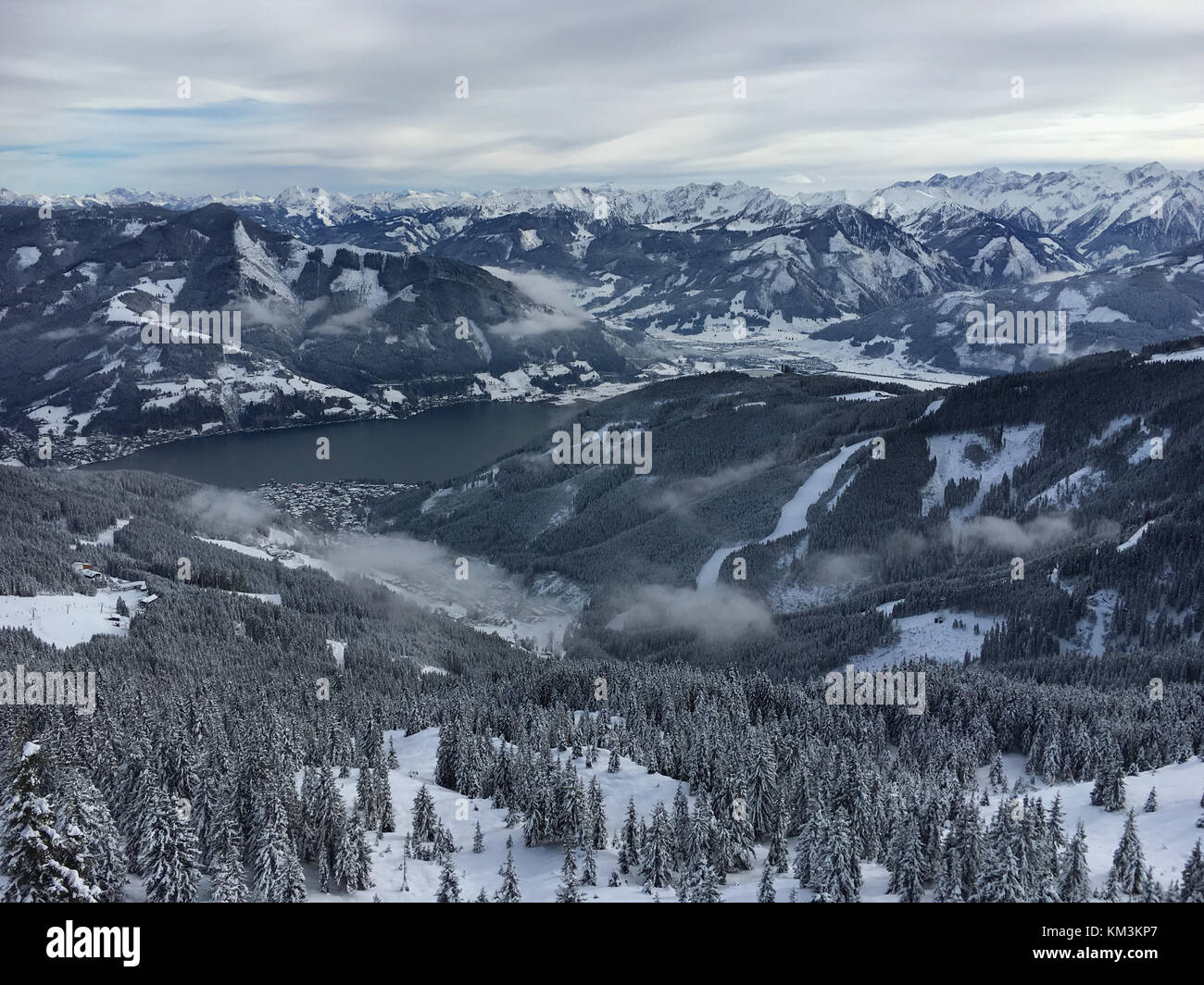 Panoramablick auf die Skipiste und den Zeller See im österreichischen Skigebiet Schmitten in den Tiroler Alpen. Stockfoto