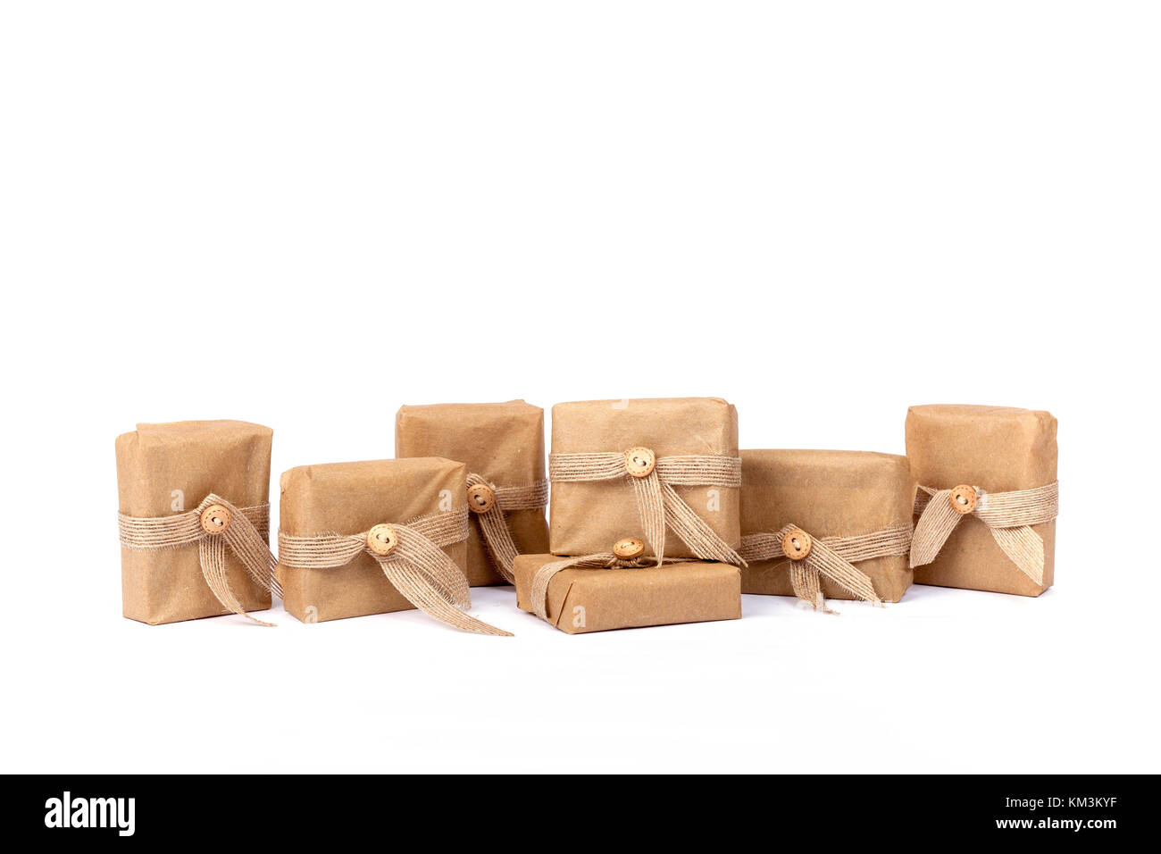 Geschenk für Weihnachten verpackt in Braun Recyclingpapier mit Schleife und isoliert auf weißem Stockfoto