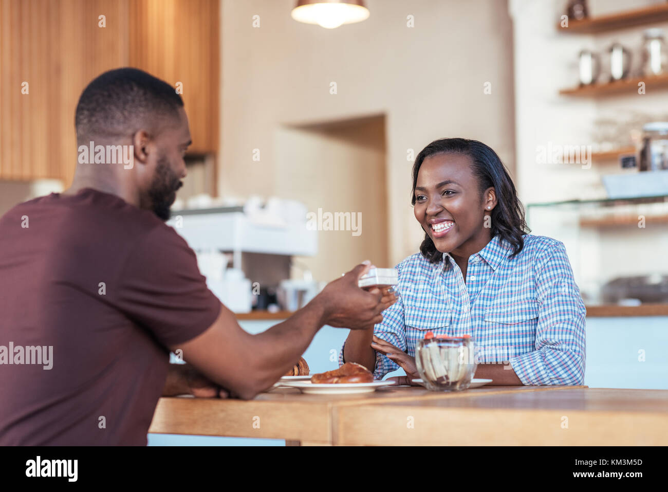 Junge afrikanische Mann, ein Geschenk zu sein lächelndes Freundin Stockfoto