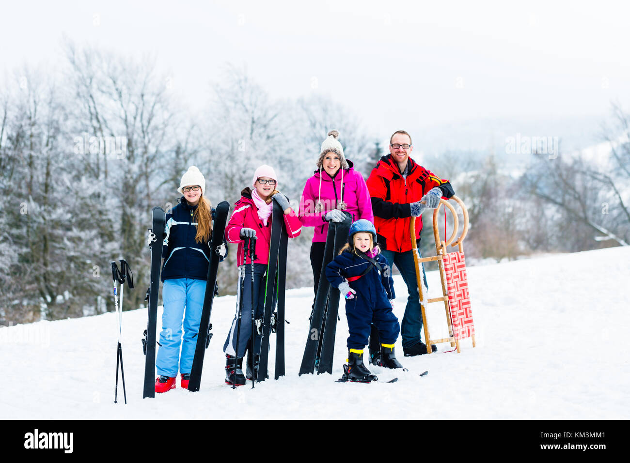 Familie im Winter Urlaub Sport im Freien mit Schlitten und Ski Stockfoto
