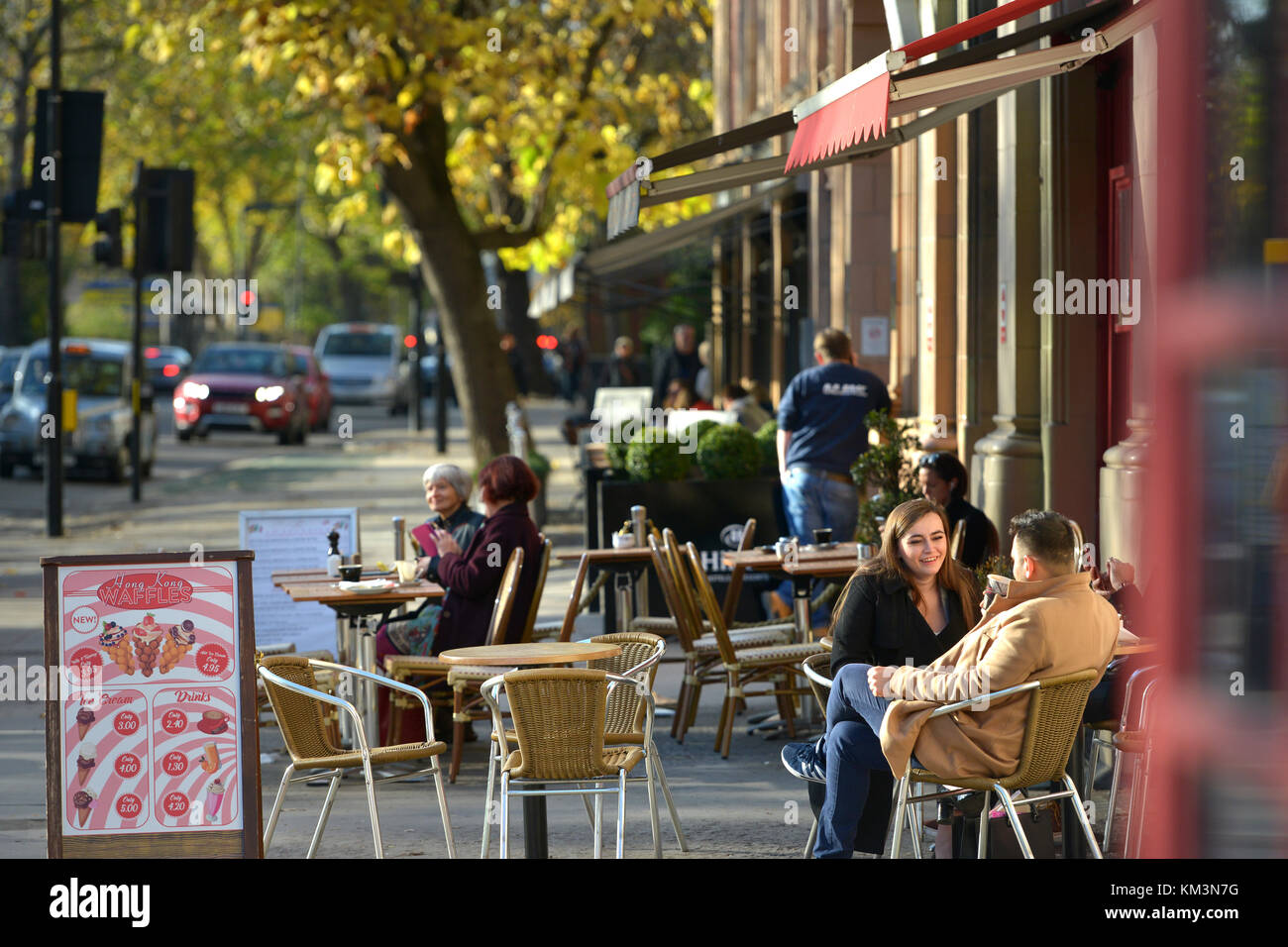 Cafe und Touristen an der Bayswater Road, London, an einem sonnigen Herbsttag Stockfoto