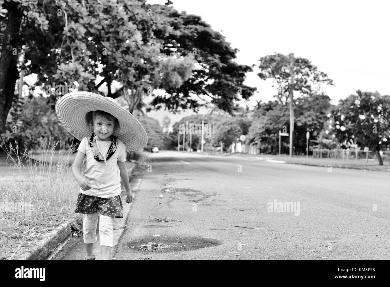 Junge Mädchen mit einem Sombrero zu Fuß in einer Vorstadtstraße, Townsville, Queensland, Australien Stockfoto