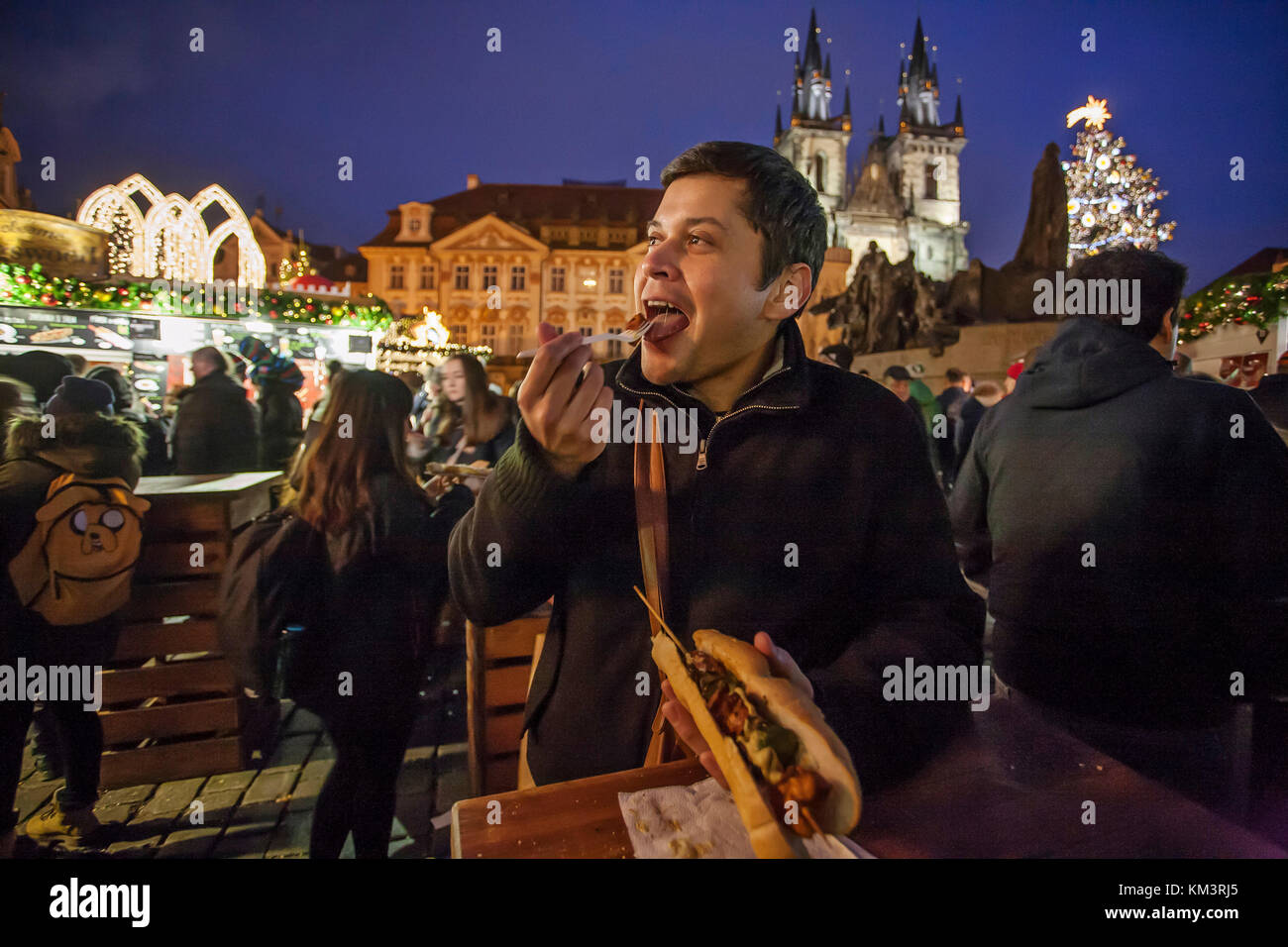 Mexikanische Touristen genießen Hot Chicken Fleischspieße von Weihnachten Kiosk während der Weihnachtsfeier der Beleuchtung einen Weihnachtsbaum am Altstädter Ring in Pr Stockfoto
