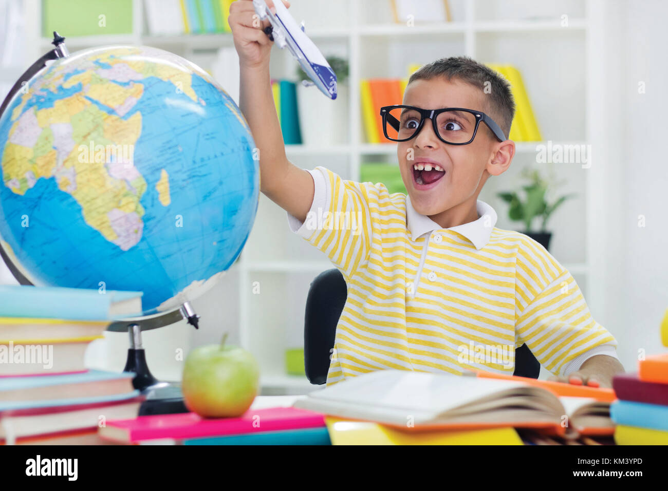 Jungen spielen mit Spielzeug und nicht nicht seine Hausaufgaben zu machen Stockfoto