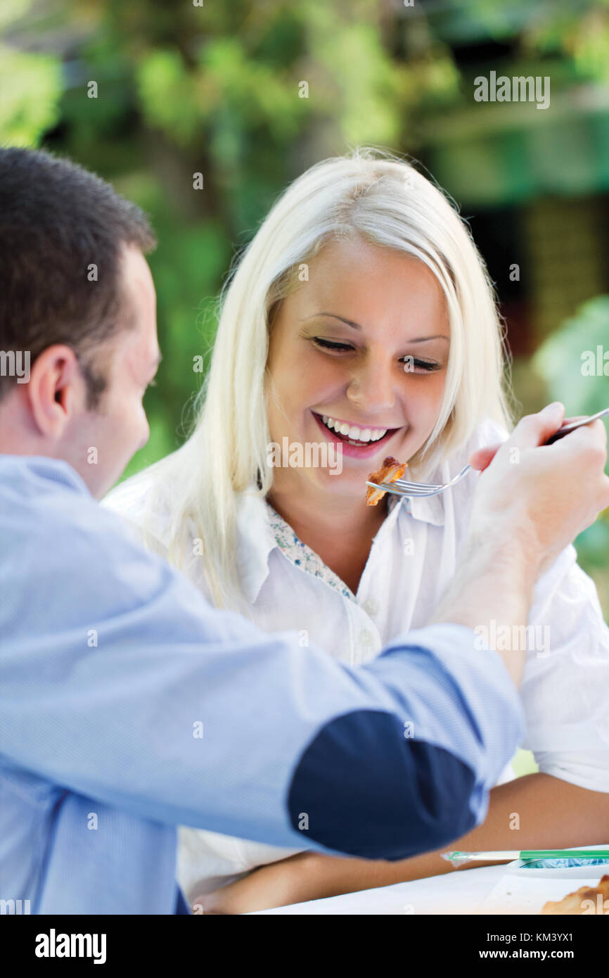 Freundlich lächelndes Paar mit Mittagessen Stockfoto