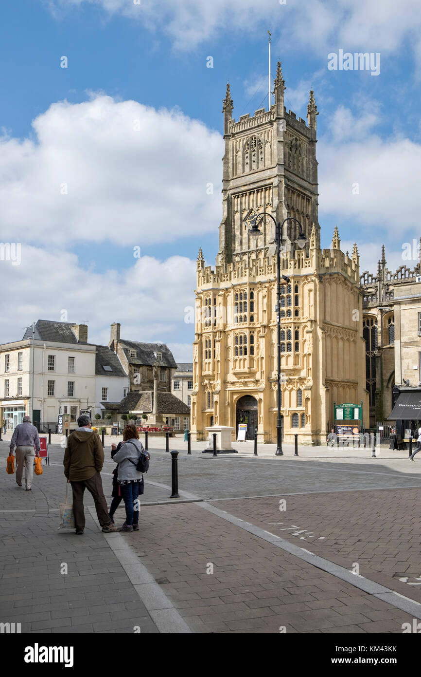 Den Marktplatz im Zentrum der Stadt Cirencester Gloucestershire, Vereinigtes Königreich. an einem sonnigen Tag, die Kirche des Hl. Johannes des Täufers. Stockfoto