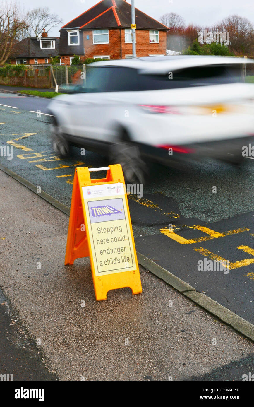 Gelb Kunststoff ein Board Warnung Treiber nicht im Zick-Zack-Linien vor Schulen Park, Lancashire, Großbritannien Stockfoto