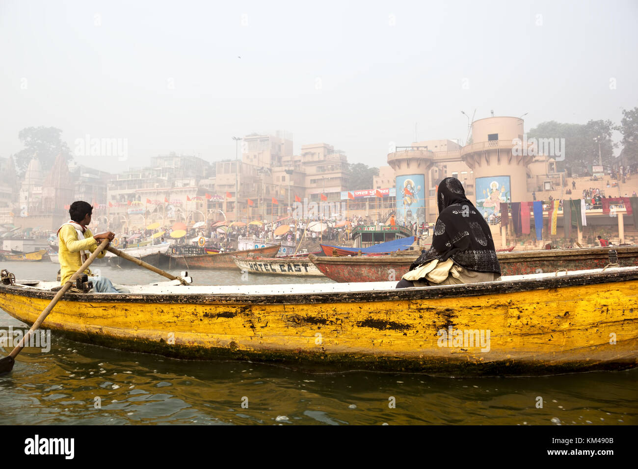 Eine ausländische Touristen genießen den Blick auf ghats durch den heiligen Fluss Ganges Touren auf einem hölzernen Ruderboot, Varanasi, benares, Kashi, Indien Stockfoto