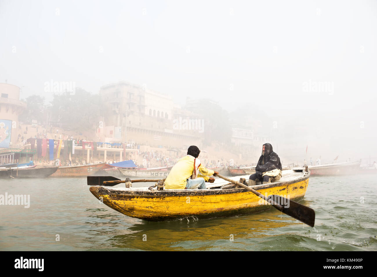 Eine ausländische Touristen genießen den Blick auf ghats durch den heiligen Fluss Ganges Touren auf einem hölzernen Ruderboot, Varanasi, benares, Kashi, Indien Stockfoto