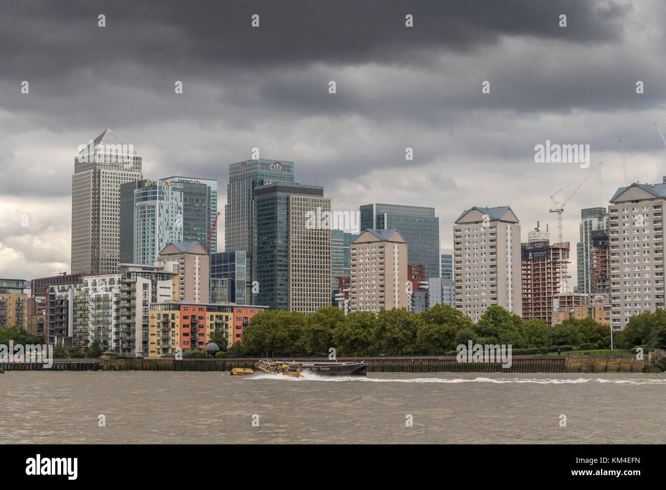 Die Towers of Canary Wharf überblicken Apartments, Wohnungen und Häuser am Ufer der Themse, London, Großbritannien Stockfoto