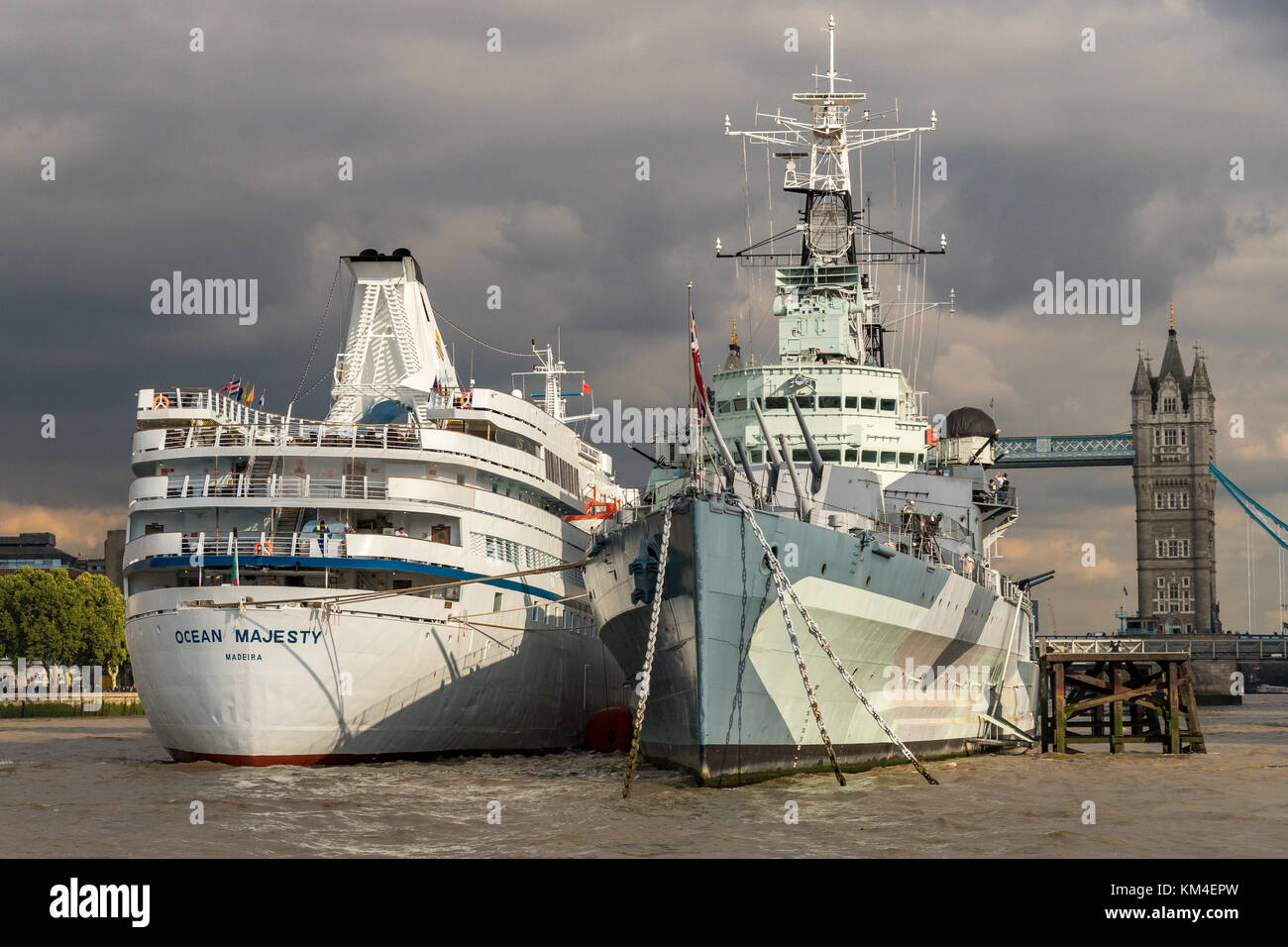 HMS Belfast mit dem Kreuzfahrtschiff MV Ocean Majesty festgemacht an der Seite in den Pool von London, Tower Bridge im Hintergrund Stockfoto