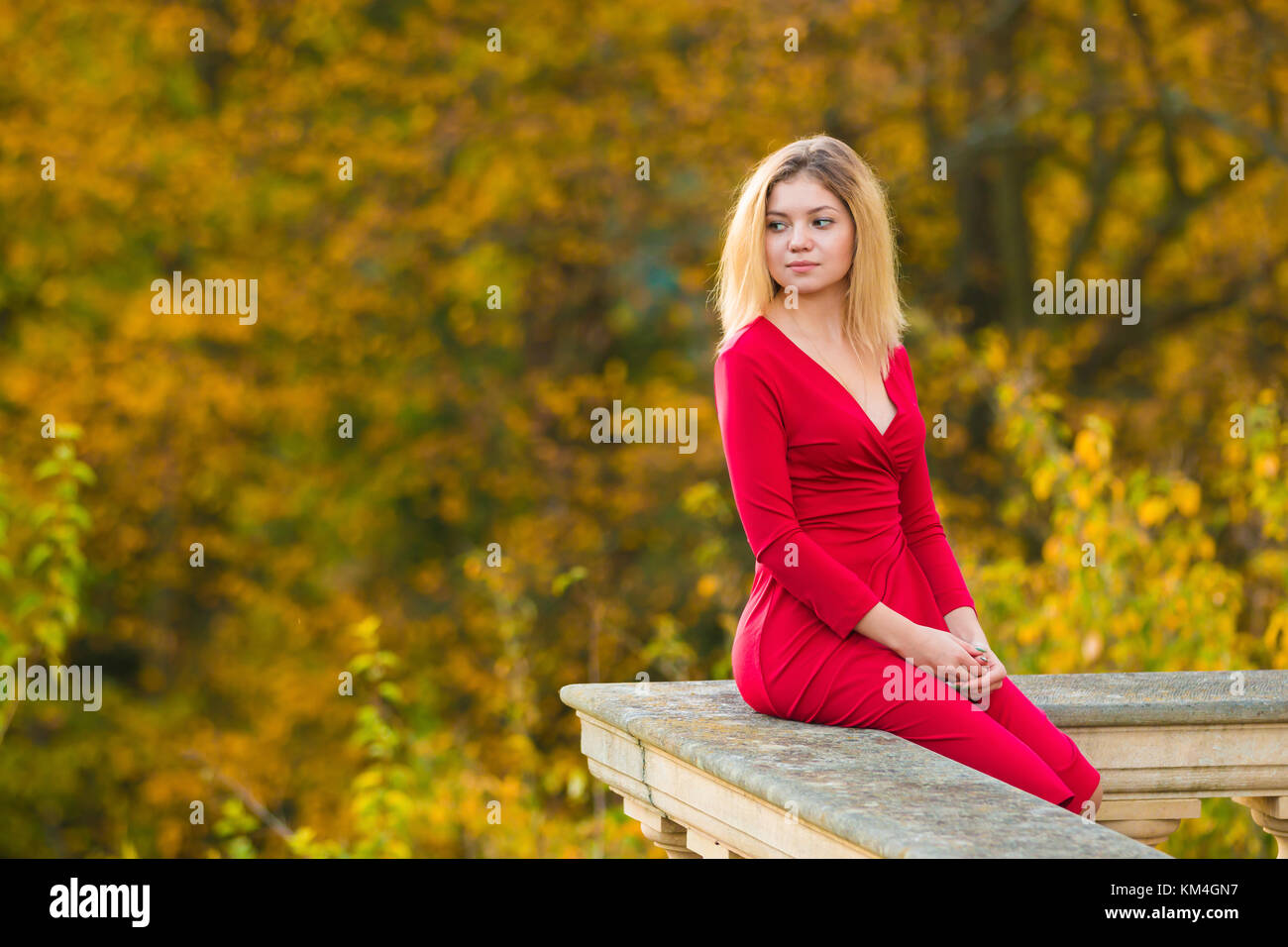 Schöne Frau im roten Kleid und alten Arhitektur auf Herbst Natur Hintergrund Stockfoto