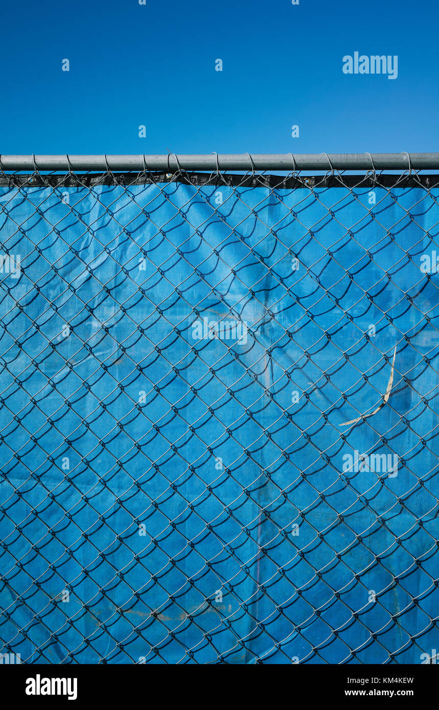 Blauen Stoff hinter chainlink Fence, blaue Himmel. Stockfoto