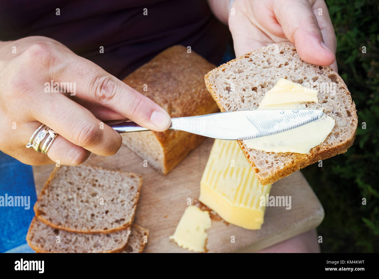 Eine Person zustimmen Brot mit einem Messer, Zubereitung von Speisen. Stockfoto