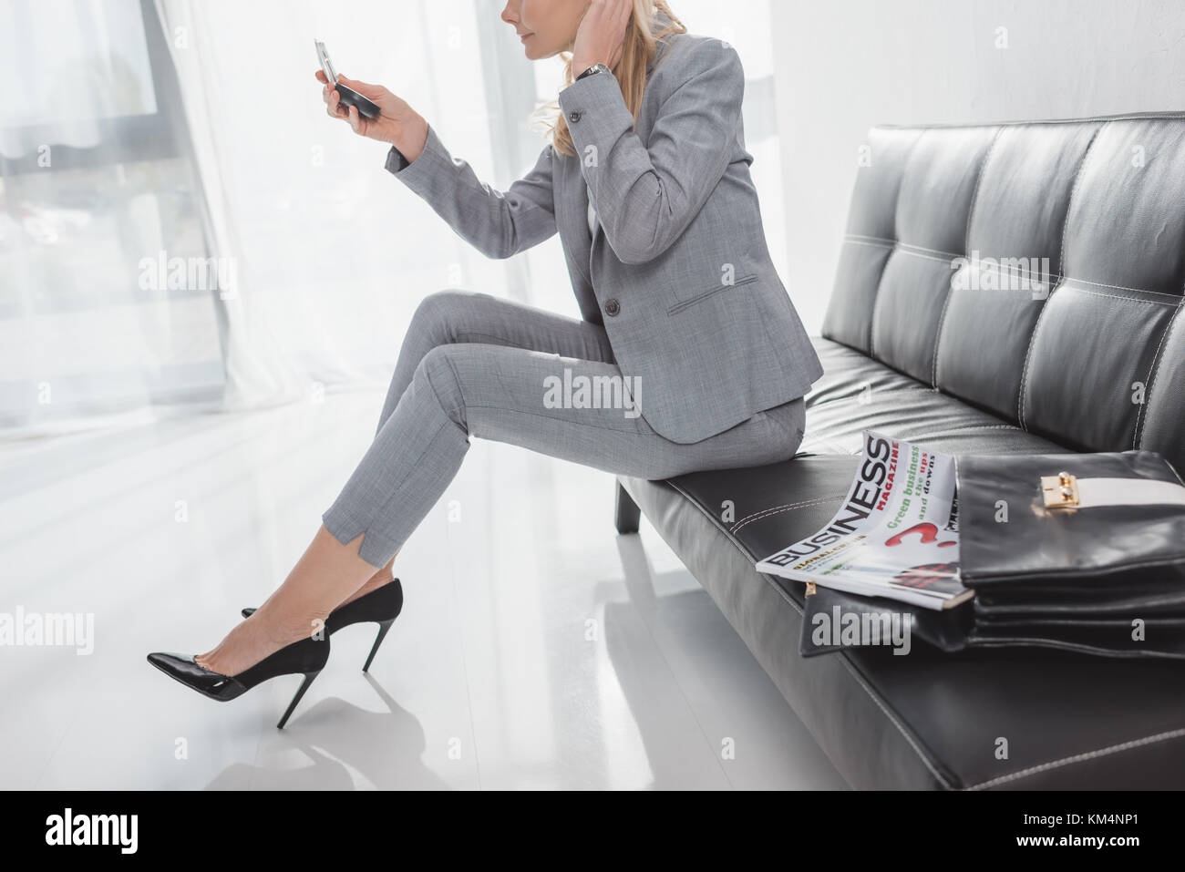 Geschäftsfrau, Kosmetikspiegel, während auf die Couch im Wartezimmer sitzen Stockfoto