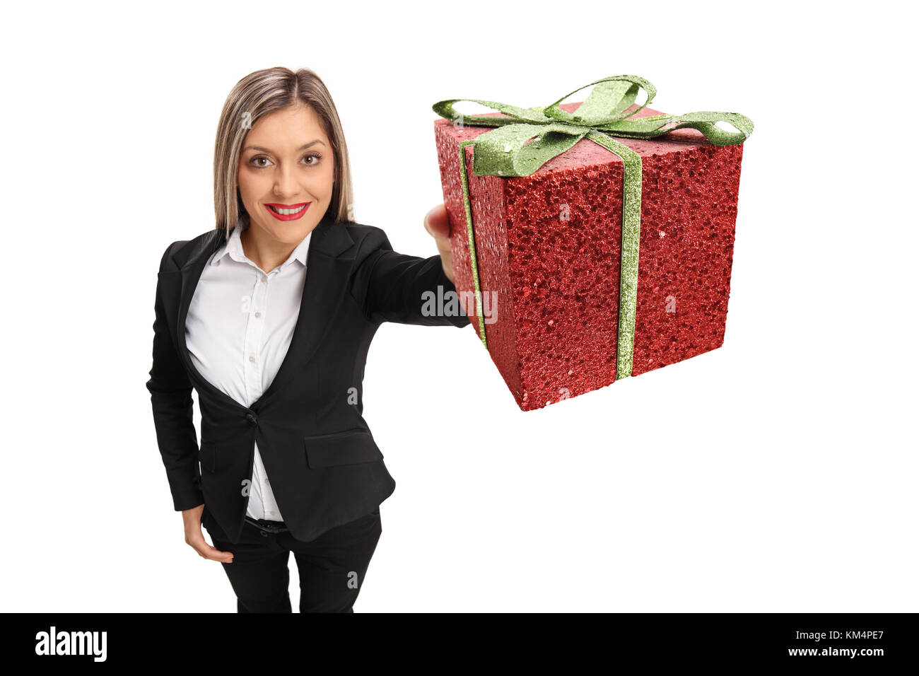 Formal Mädchen zeigen ein Geschenk auf weißem Hintergrund gekleidet Stockfoto