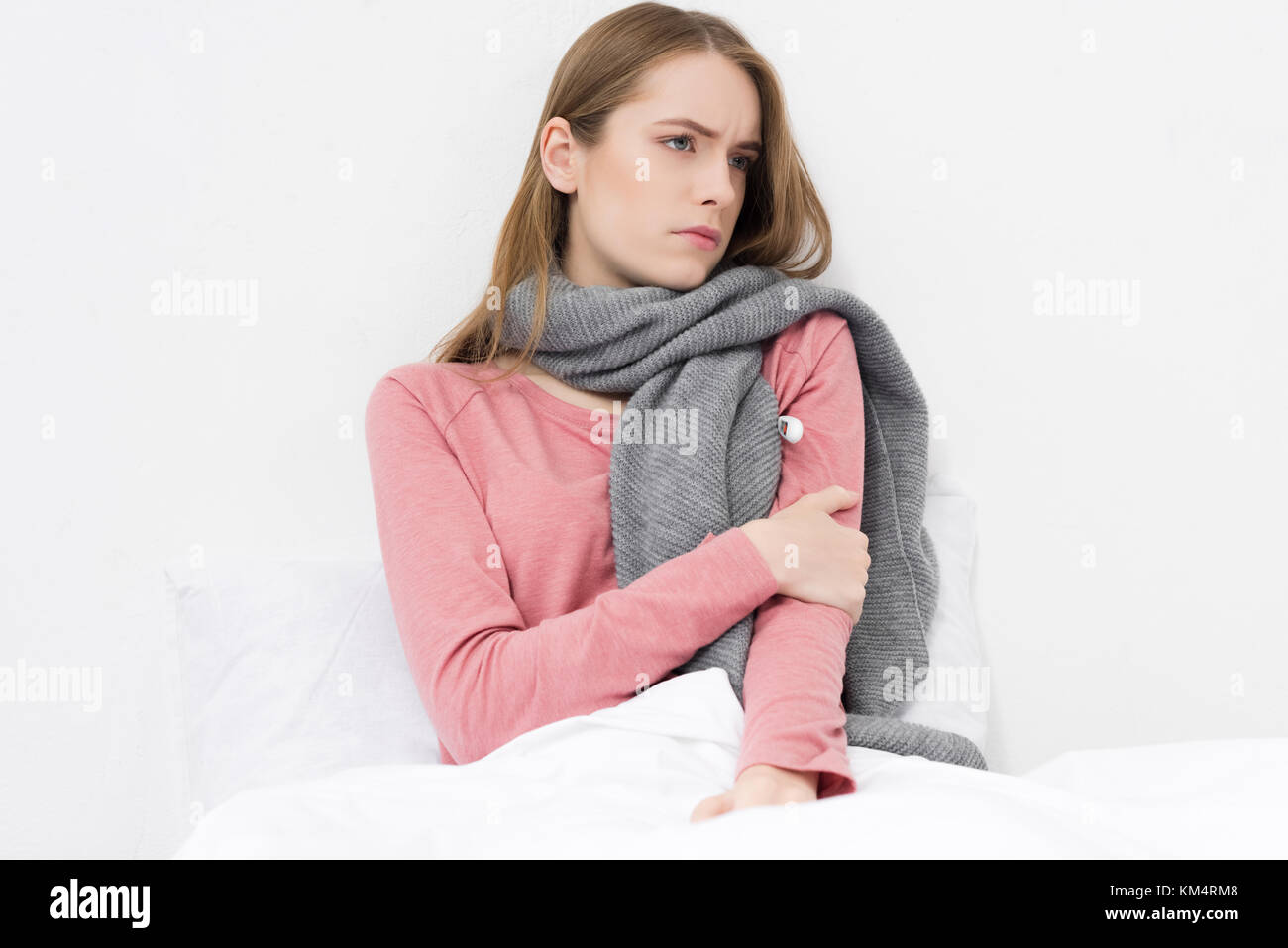 Mädchen im Bett liegend mit Thermometer Stockfoto