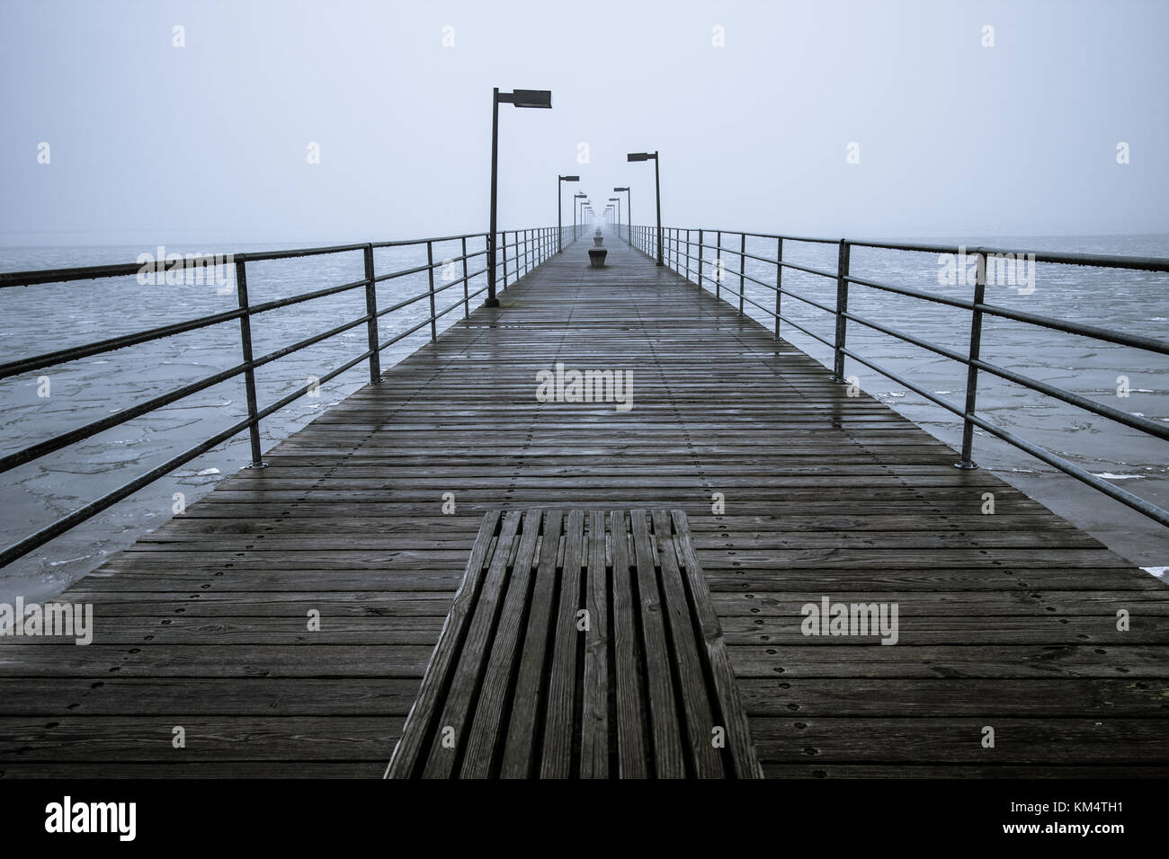Lange Holzsteg. Holzsteg eingehüllt in Nebel in den Horizont. Harbour Beach, Michigan, USA. Stockfoto