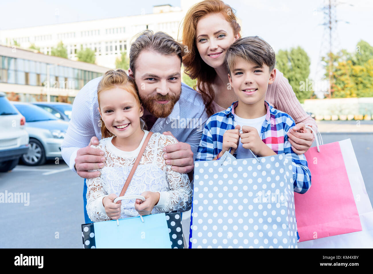 Eltern umarmt Kinder mit Tüten Stockfoto