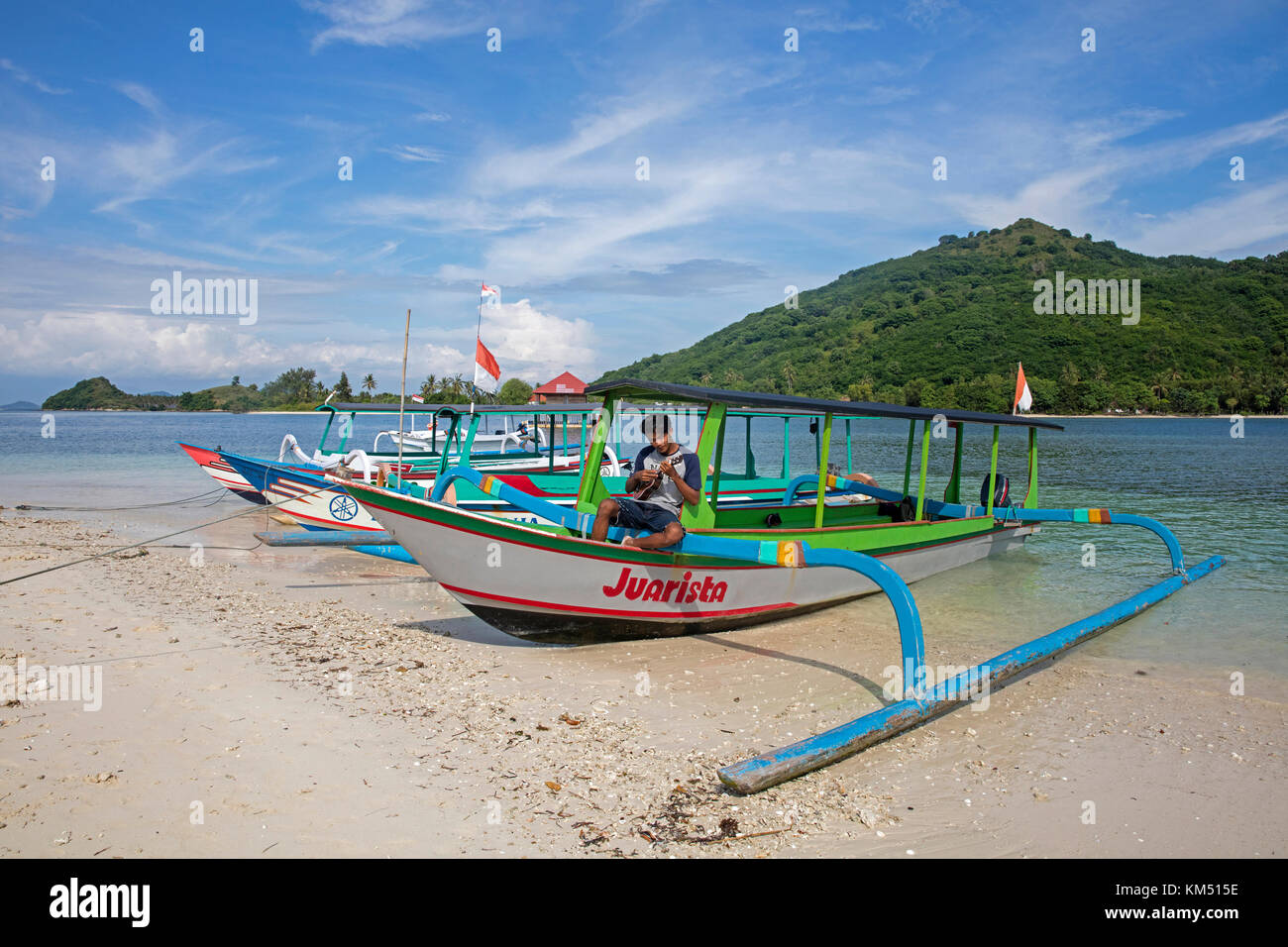 Indonesische Reiseführer spielen Ukulele auf auslegerboot auf der kleinen Insel Gili Nanggu, Gili Inseln, Insel Lombok, Kleine Sunda-Inseln, Indonesien Stockfoto