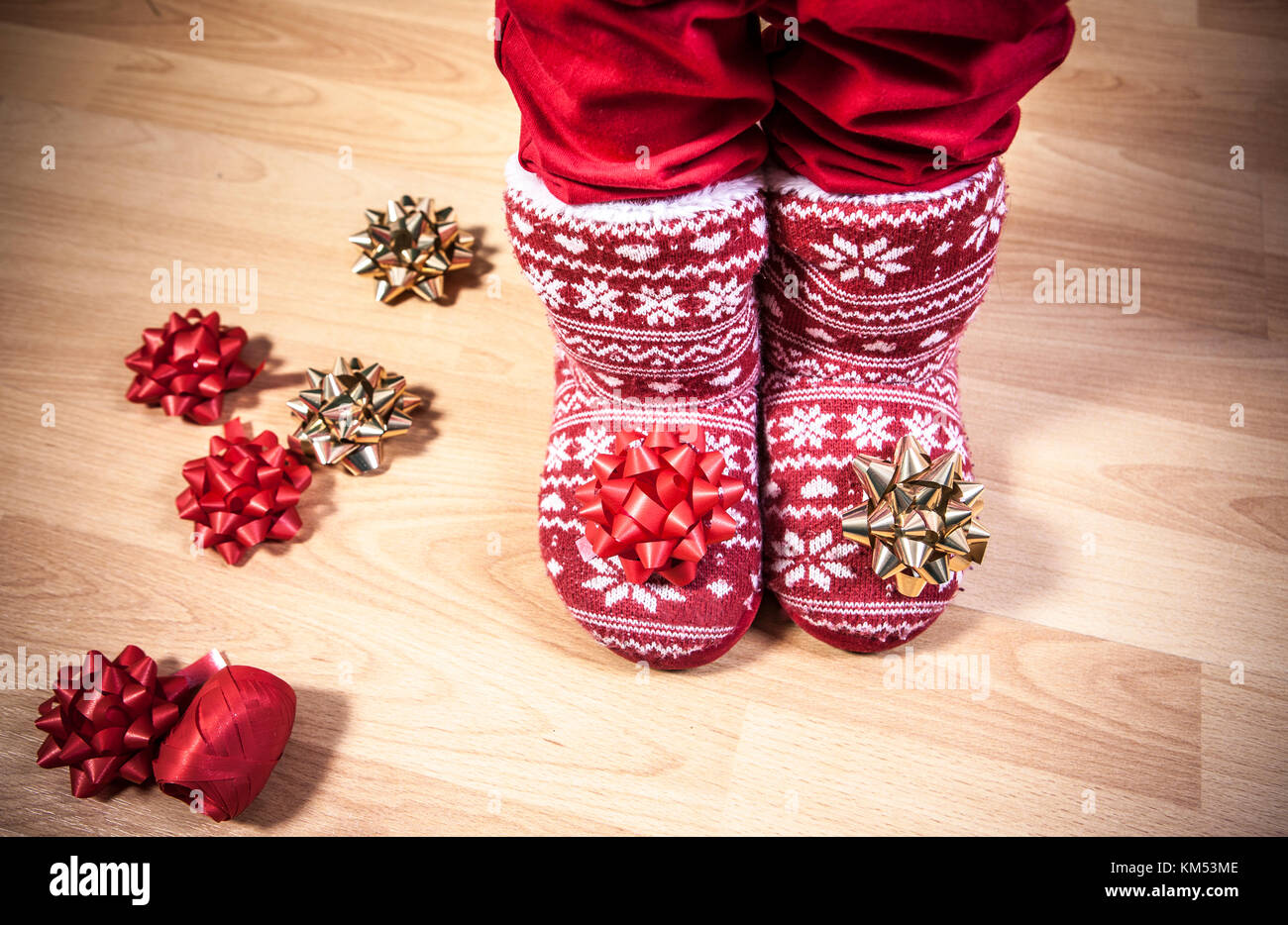 Rot gestrickt Stiefel mit Fell voller Bänder und Holzboden. Weihnachten personal Konzept Stockfoto