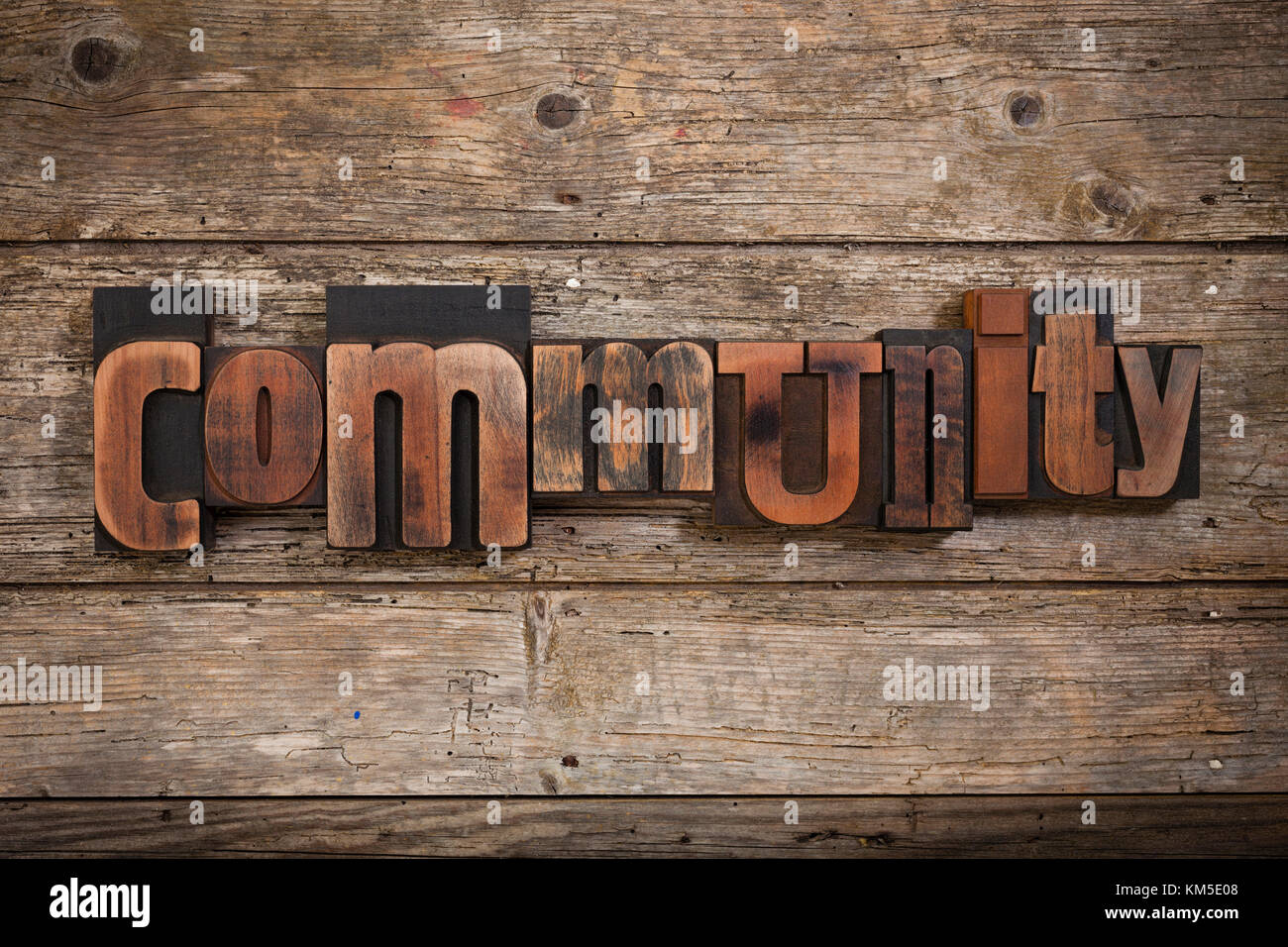 Gemeinschaft, einzelnes Wort mit Vintage Buchdruck Blöcke auf rustikalen Holzmöbeln Hintergrund Stockfoto