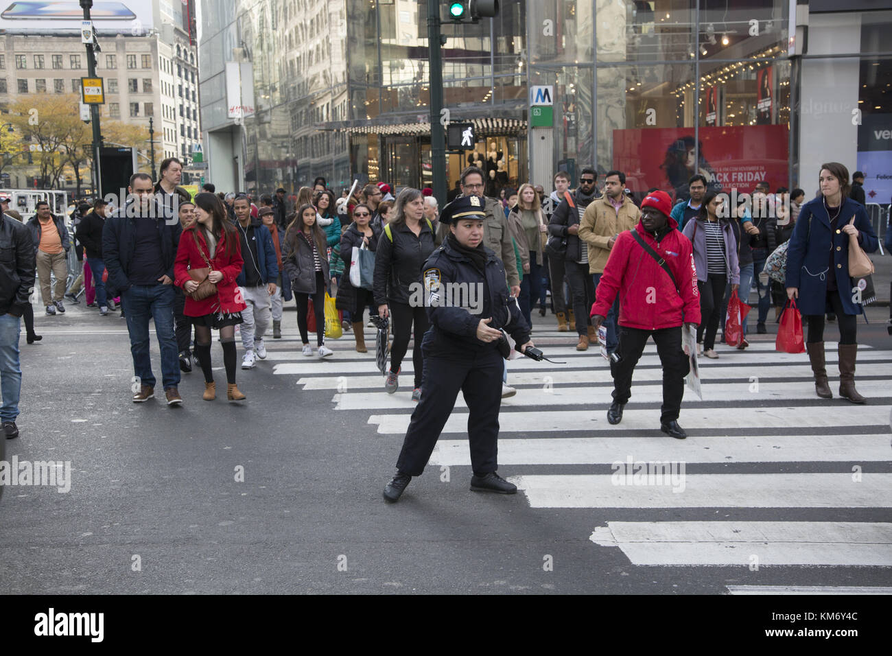 Weibliche Verkehrscop führt Autos und Fußgänger an der immer geschäftigen Kreuzung 34th Street und Broadway in New York City. Stockfoto